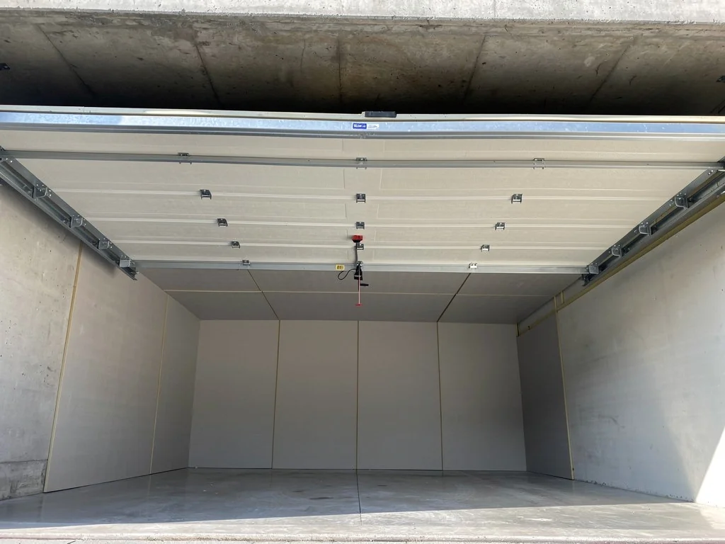 Panneaux isolants vissés au plafond d'un garage, sous la dalle béton